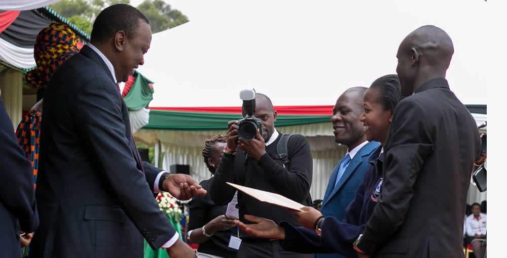 A man in a suit is shaking hands with a group of people.