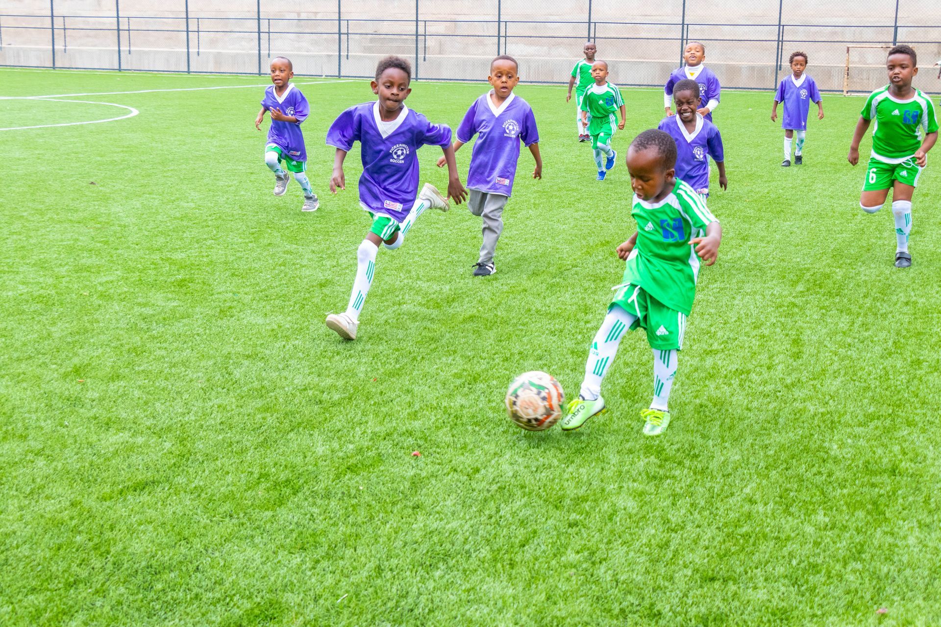 A group of young boys are playing soccer on a field.