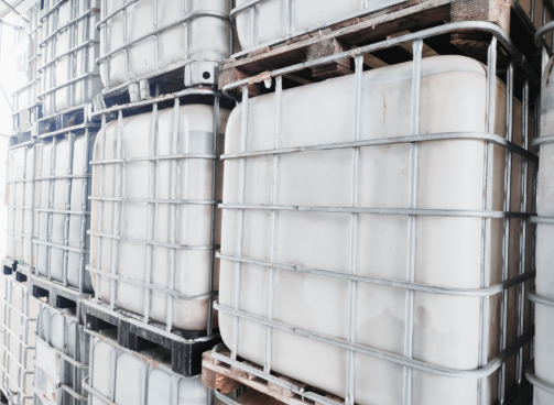 Grande camion industriale argentato sull'erba con cielo sullo sfondo.