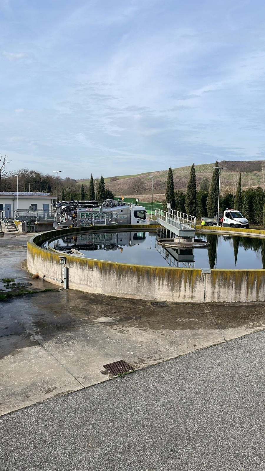 Grande camion industriale argentato sull'erba con cielo sullo sfondo.