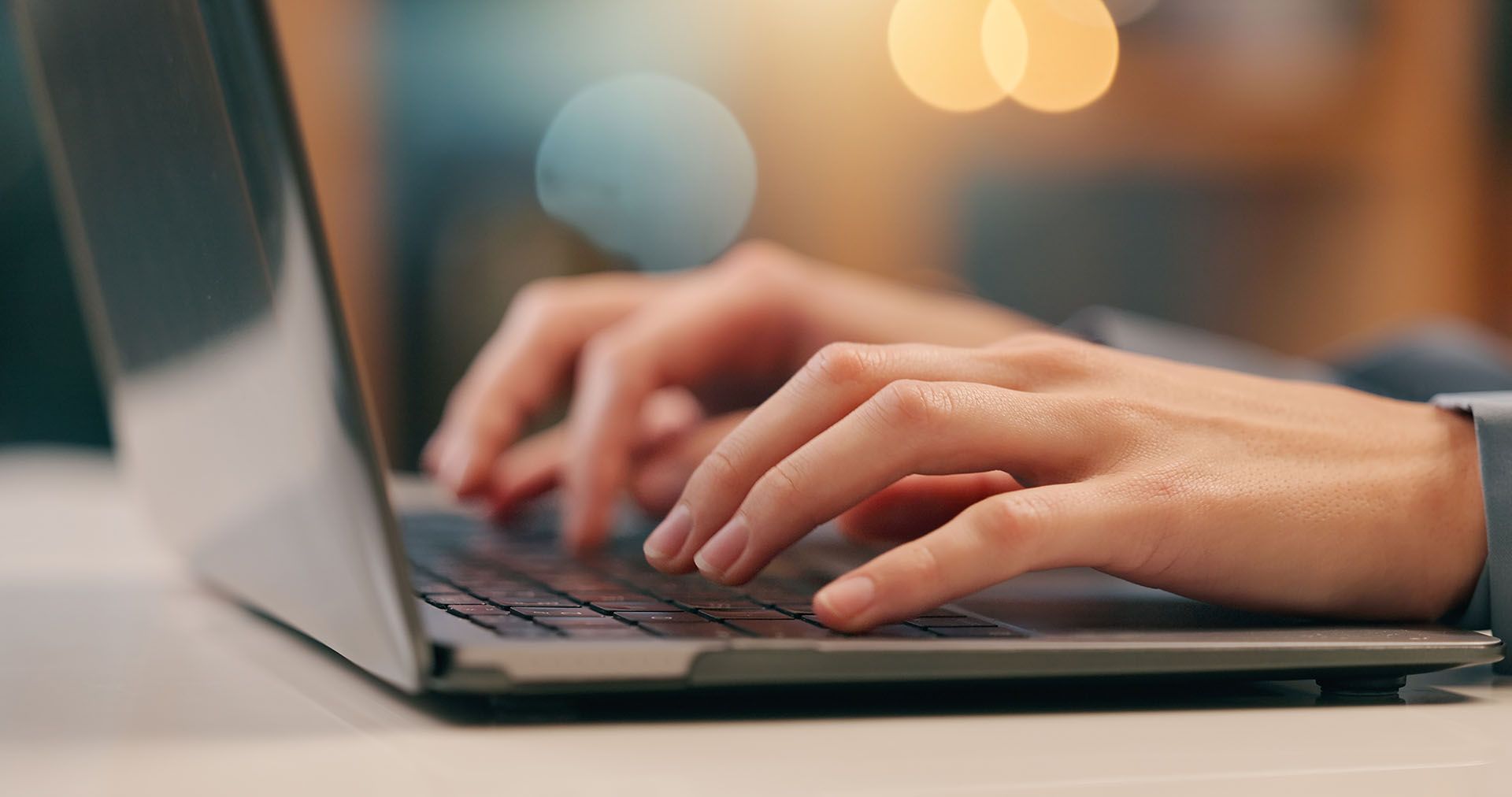 Hands typing on a laptop keyboard.