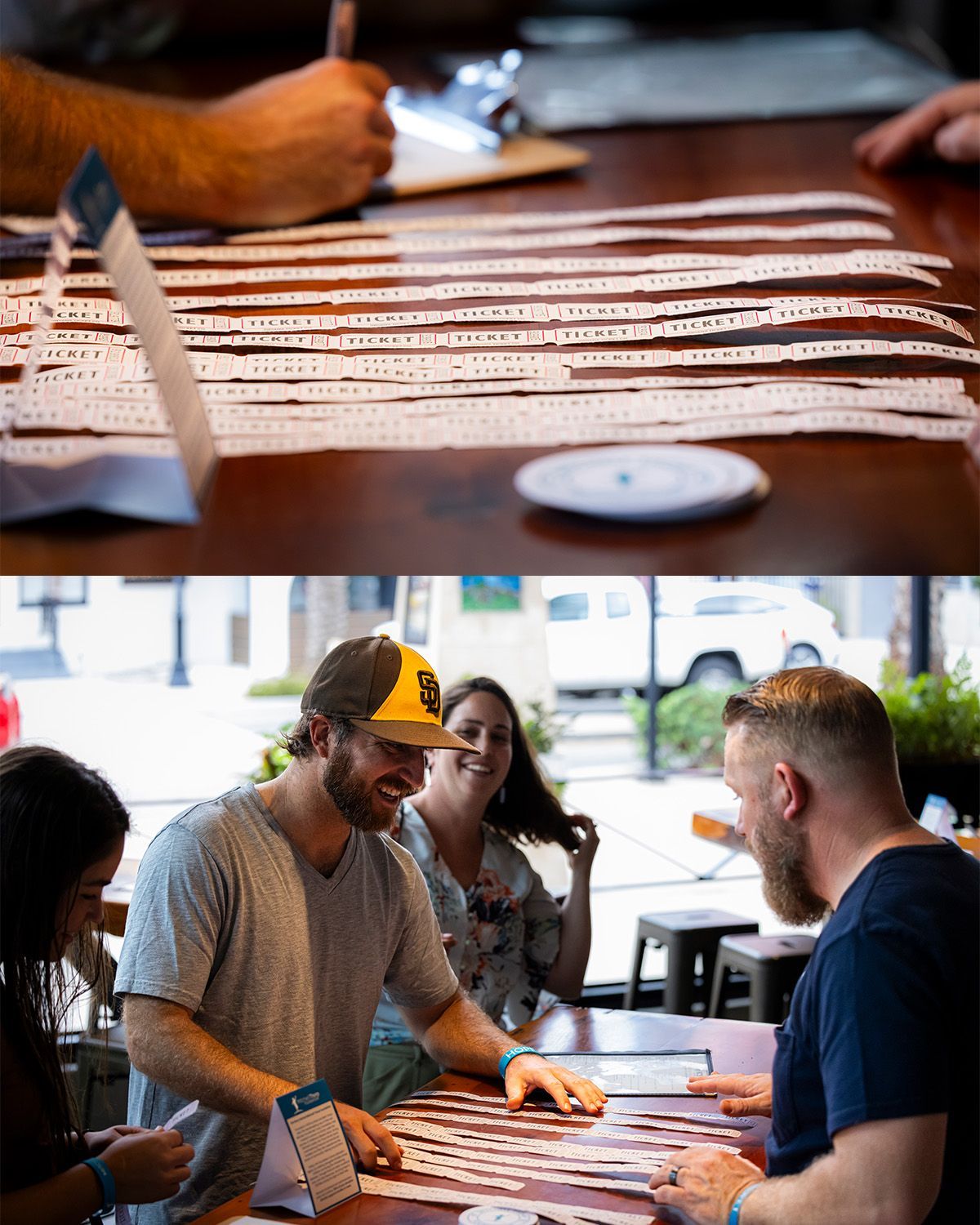 People at a table looking at long strips of paper, someone writes, likely at an event or game.