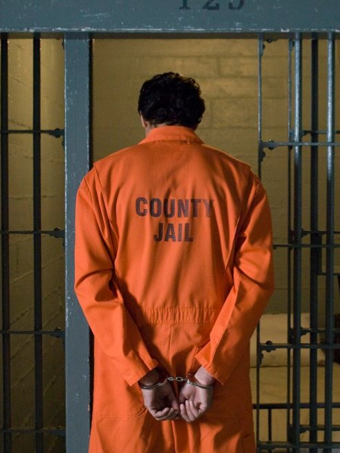 A person in an orange jumpsuit marked 