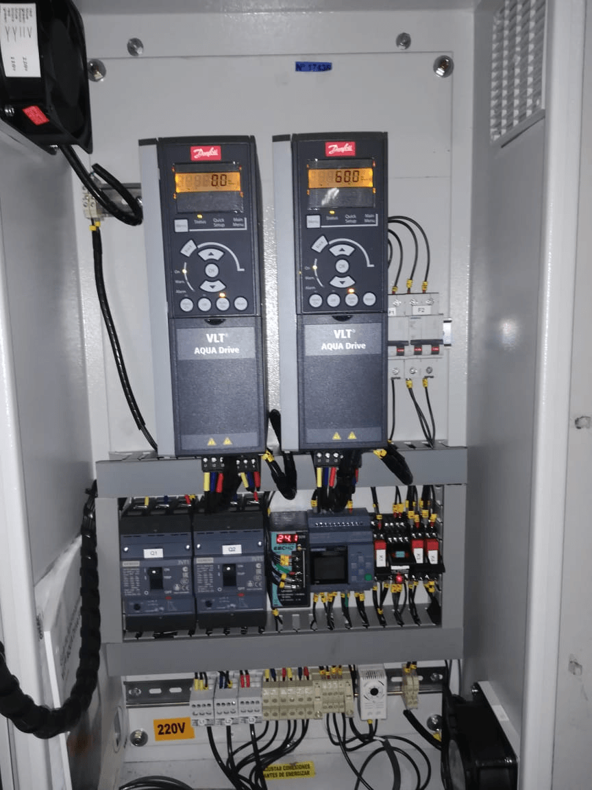 Panel de control eléctrico con dos VFD Danfoss, disyuntores y cableado.