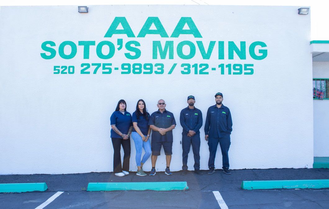 A group of people standing in front of a soto 's moving sign