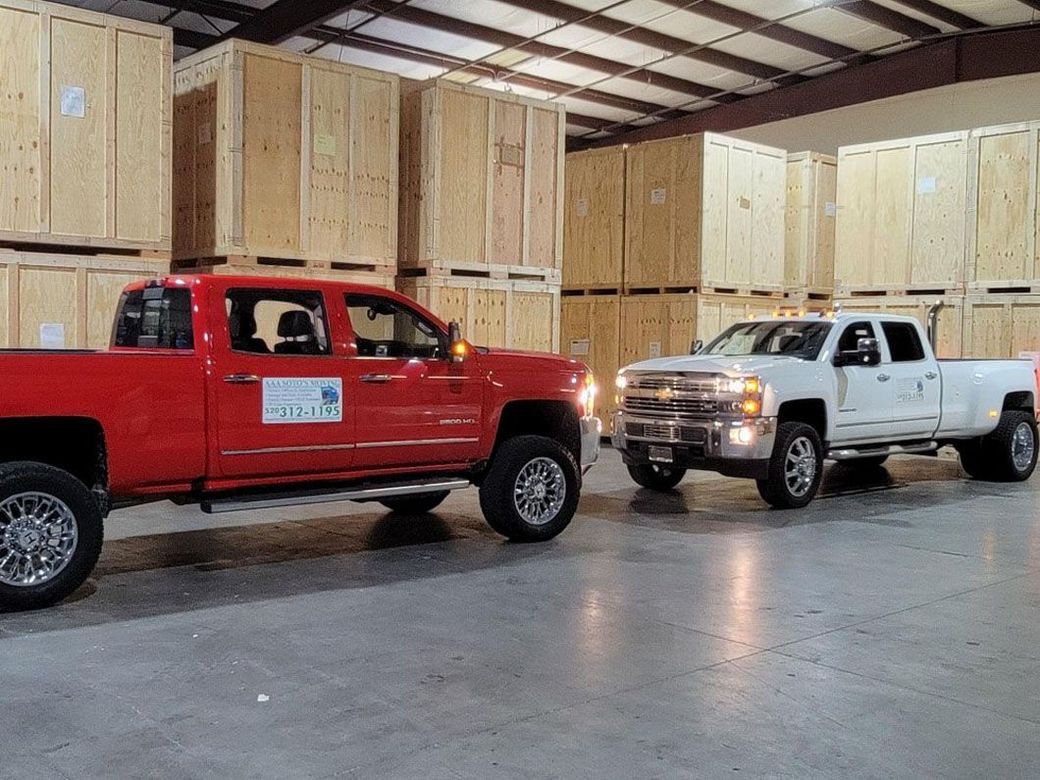 Two trucks are parked next to each other in a warehouse.