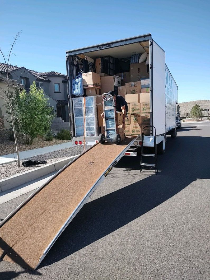 A man is loading boxes into a moving truck.