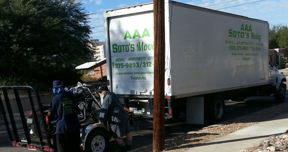 A aaa moving truck is parked on the side of the road