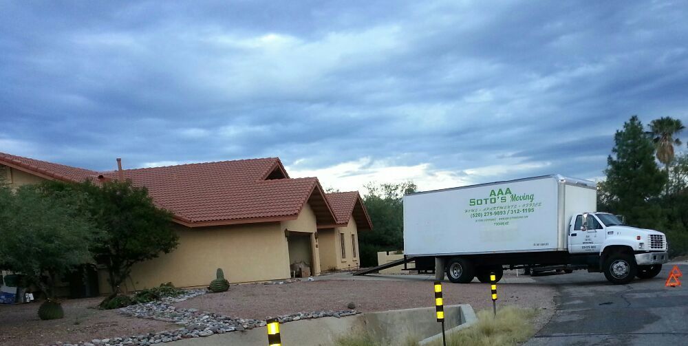A white truck is parked in front of a house.