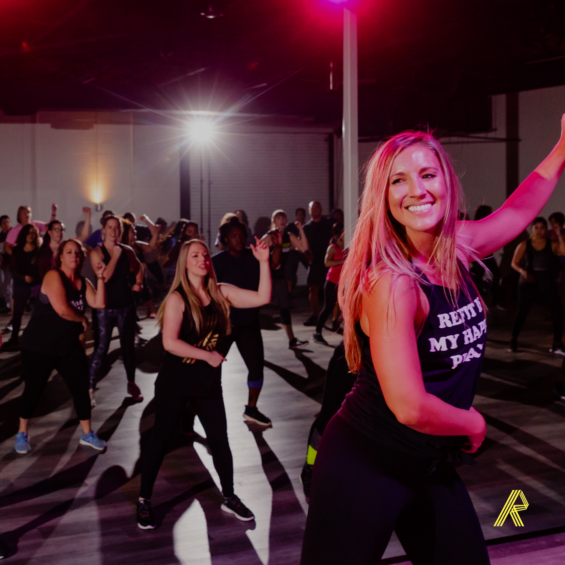 A group of women are dancing together in a gym.