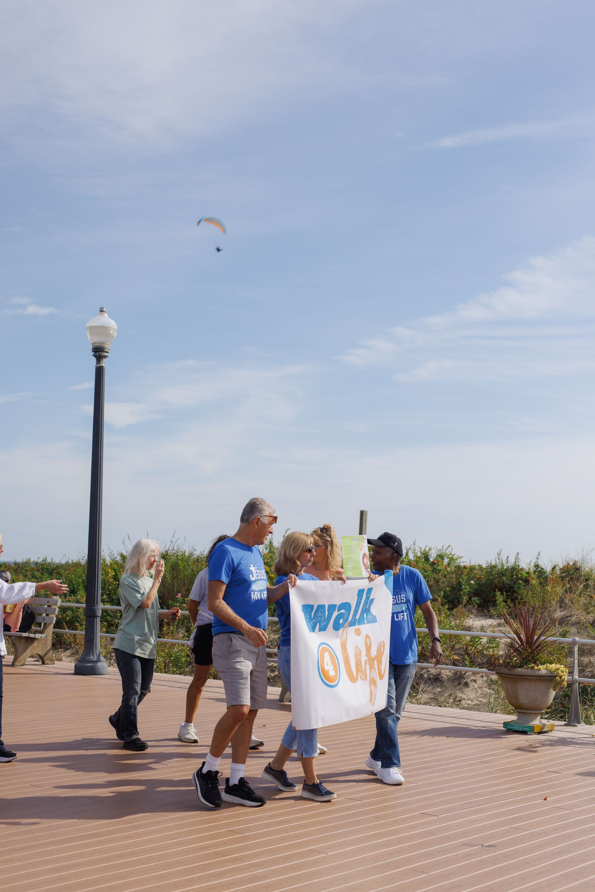 People on a boardwalk hold a