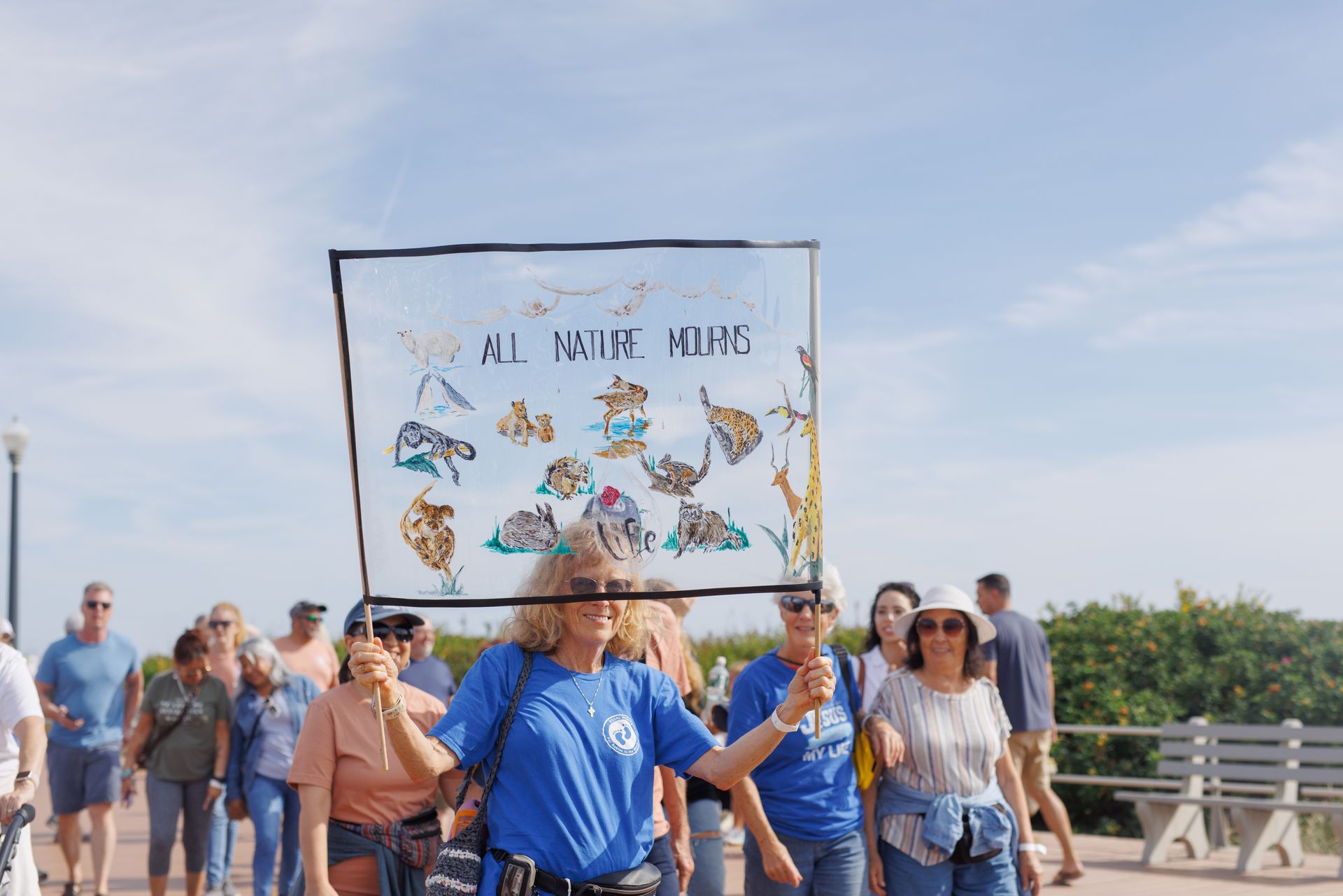 People marching, carrying a sign that says