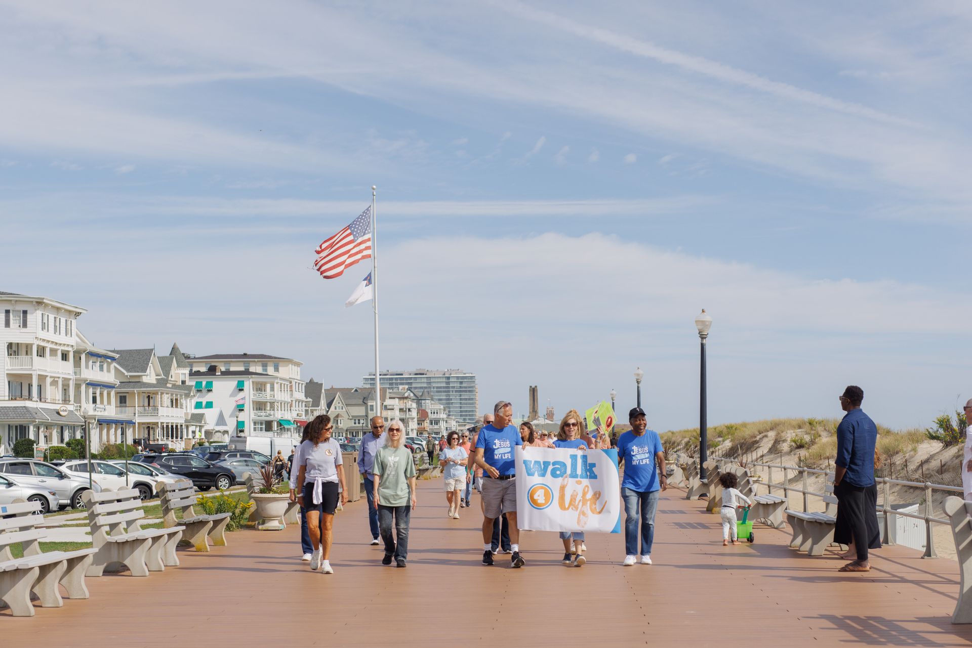 People walking on a boardwalk, holding a