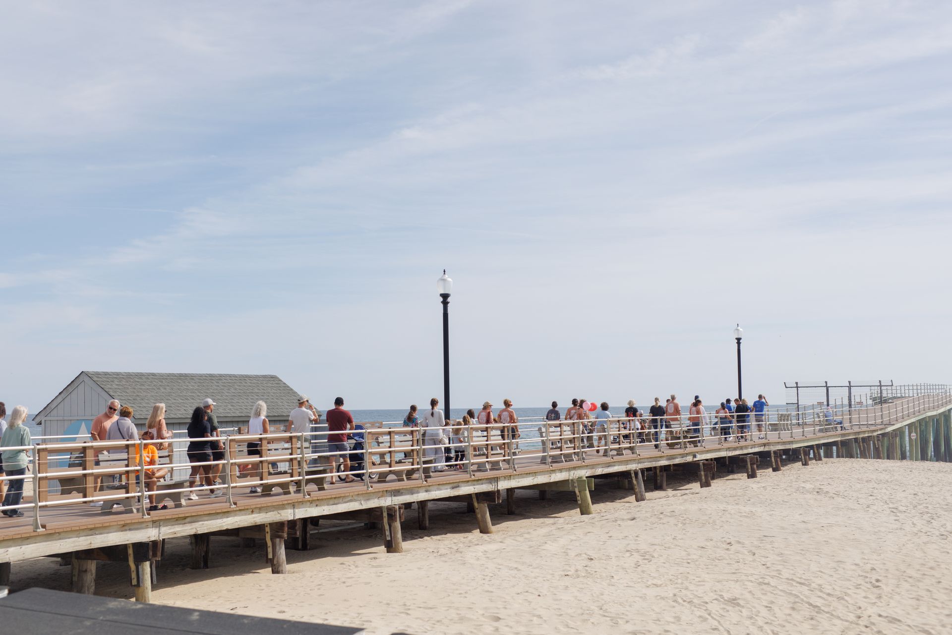 People on a wooden pier at the beach on a sunny day.