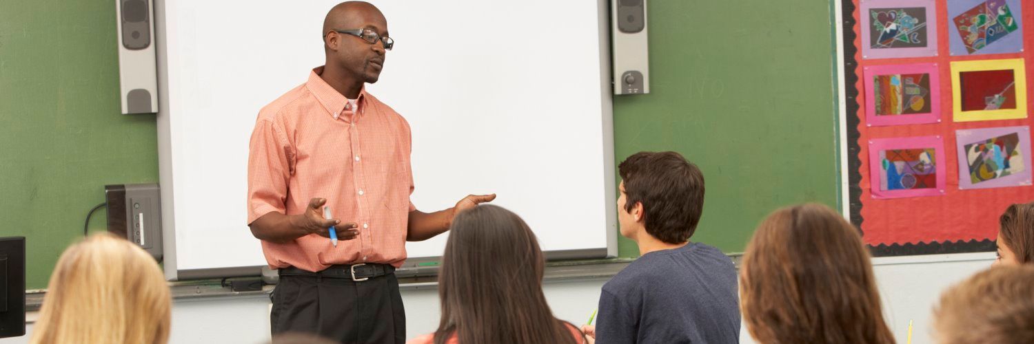 A teacher is giving a presentation to his students in a classroom.