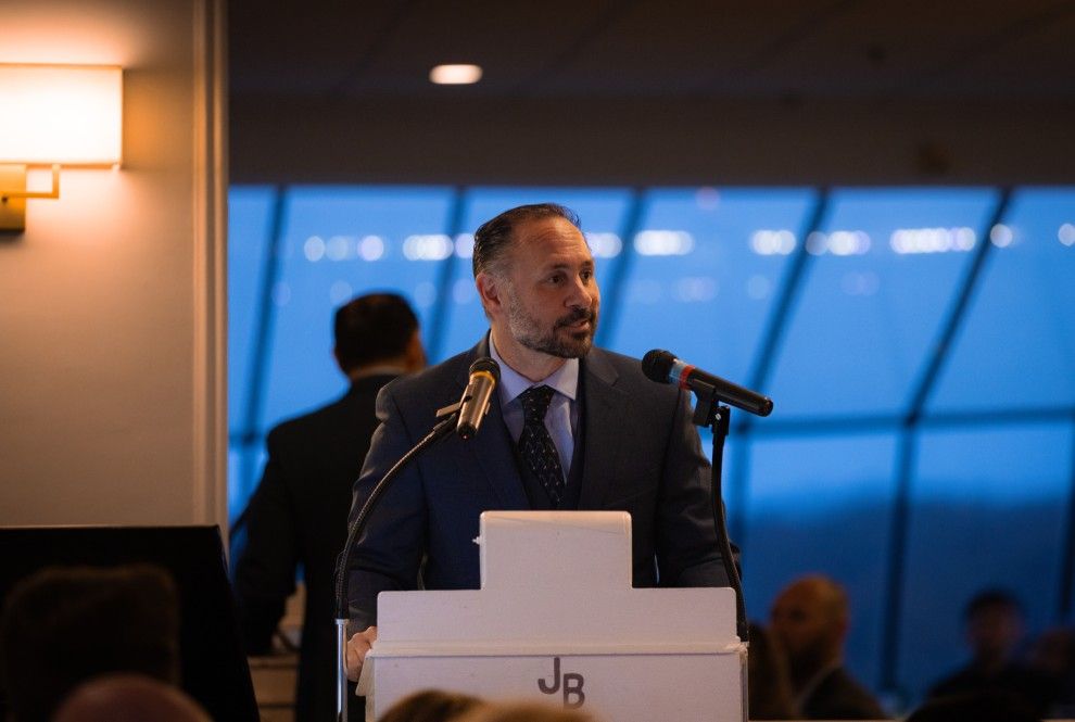 A man in a suit and tie is standing at a podium giving a speech.