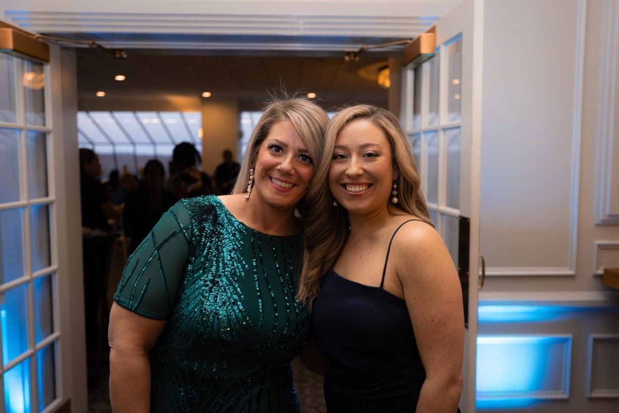 Two women are posing for a picture together in a room.