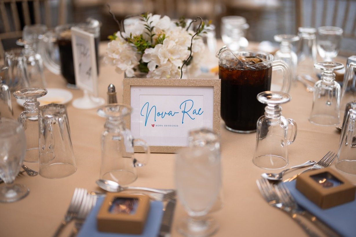 A table set for a wedding reception with a sign that says bride and groom on it.