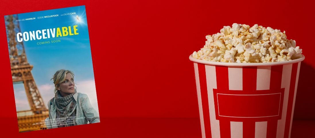 A bucket of popcorn next to a movie poster on a red background.