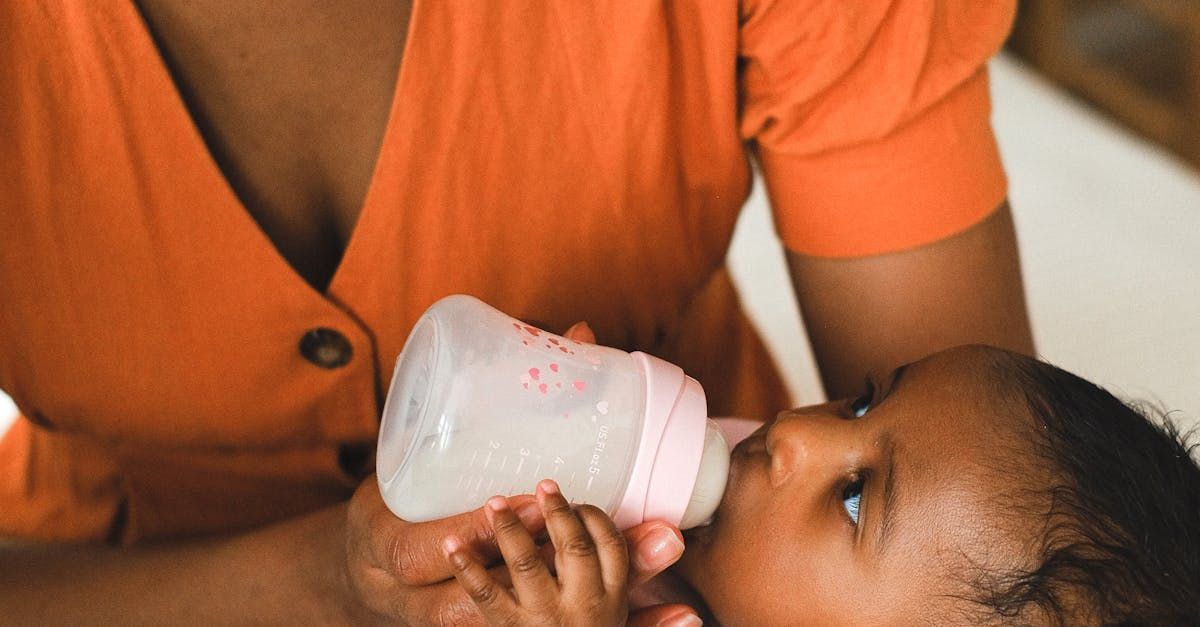 A woman is feeding a baby from a bottle.