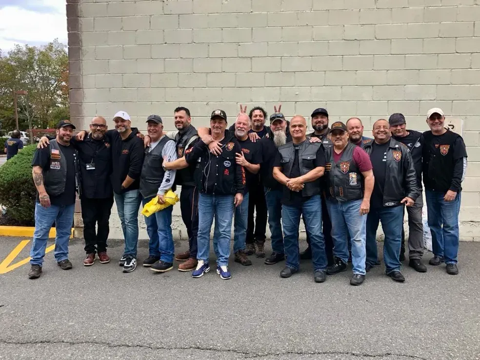 A group of men are posing for a picture in front of a brick building.