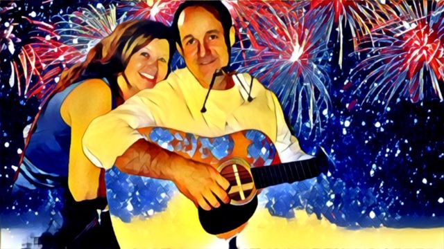 A man is playing a guitar in front of a fireworks display