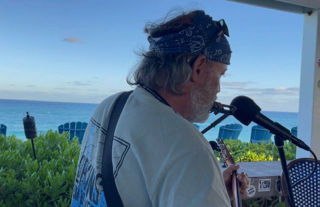 A man is playing a guitar and singing into a microphone.