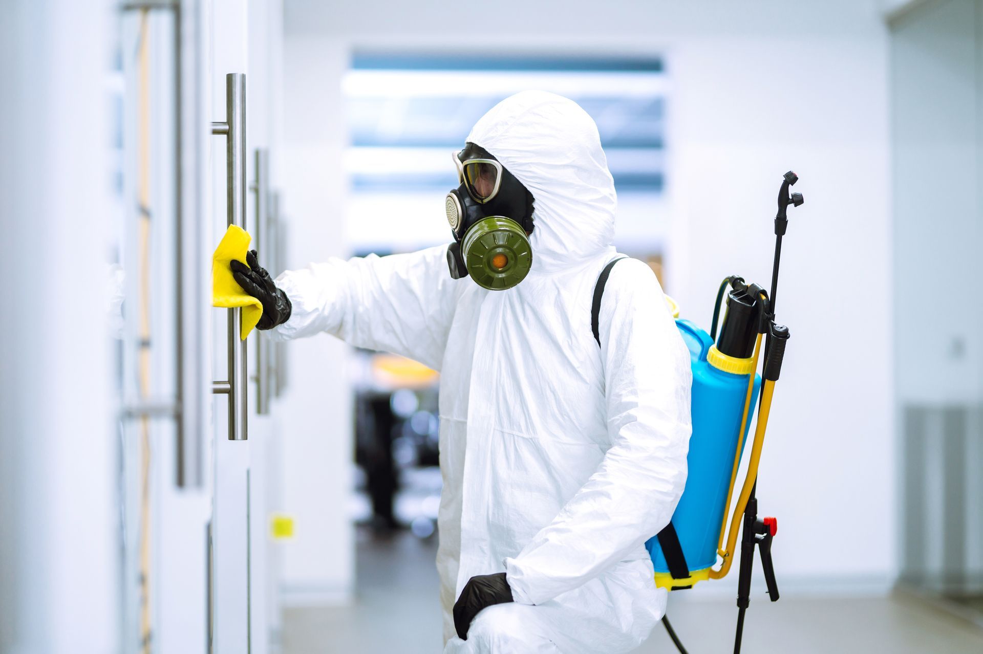 Cleaning and disinfection of office to prevent COVID-19, Man in protective hazmat suit washes office furniture to preventing the spread of coronavirus, pandemic in quarantine city.