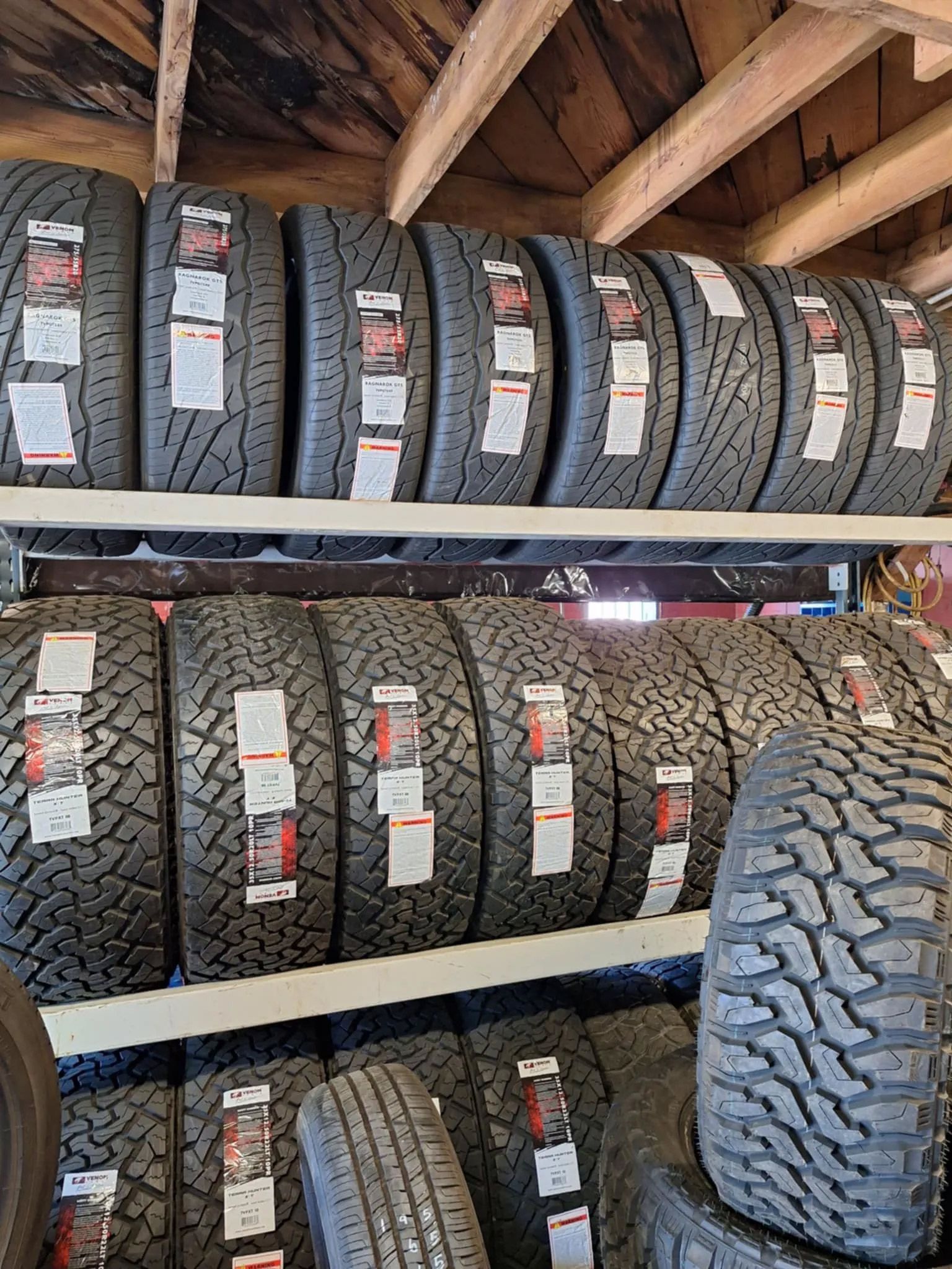 A bunch of tires are stacked on top of each other on a shelf.