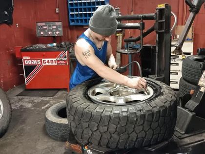 A man is changing a tire in a tire shop