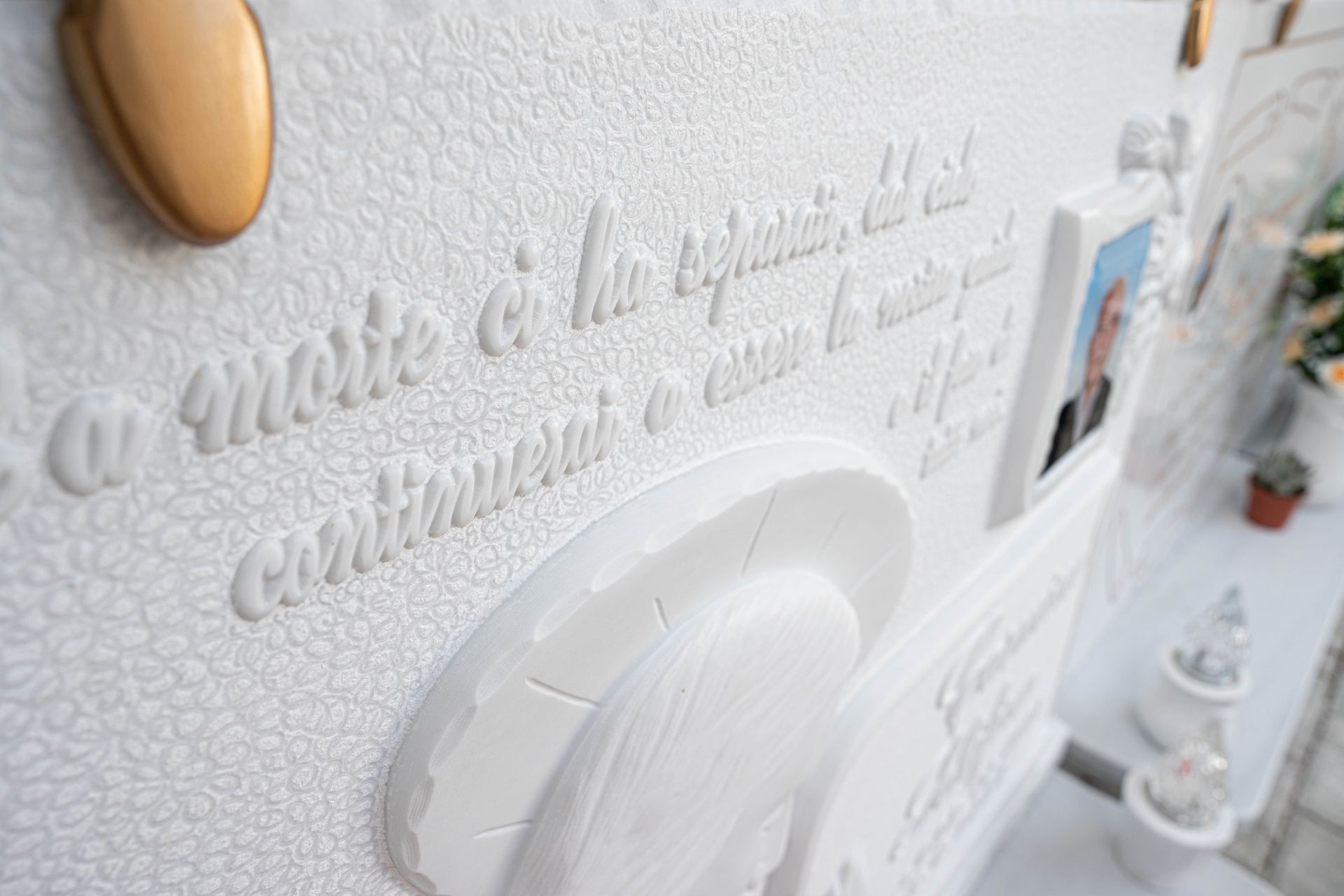 Un muro bianco con un quadro e una citazione.