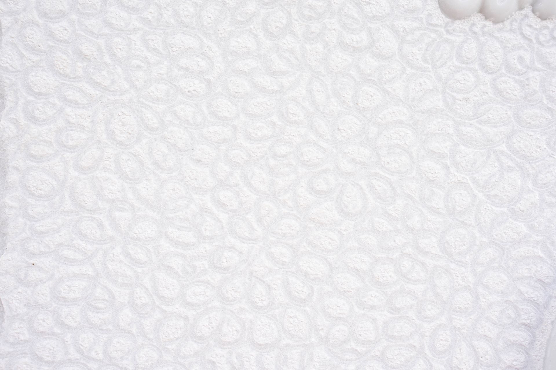 Un primo piano di una coperta bianca con un motivo.