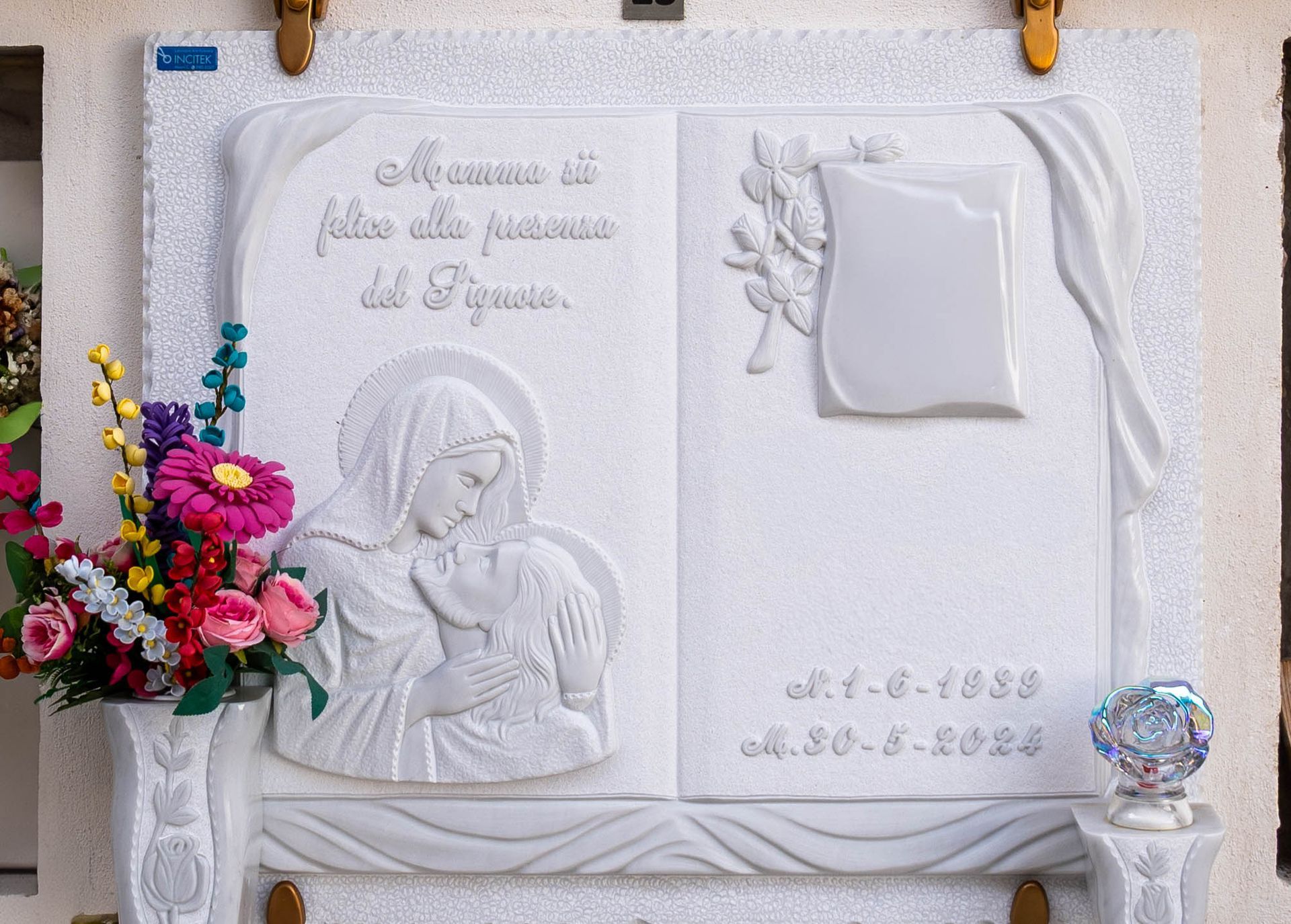 Una lapide con l'immagine di una donna che tiene in braccio un bambino