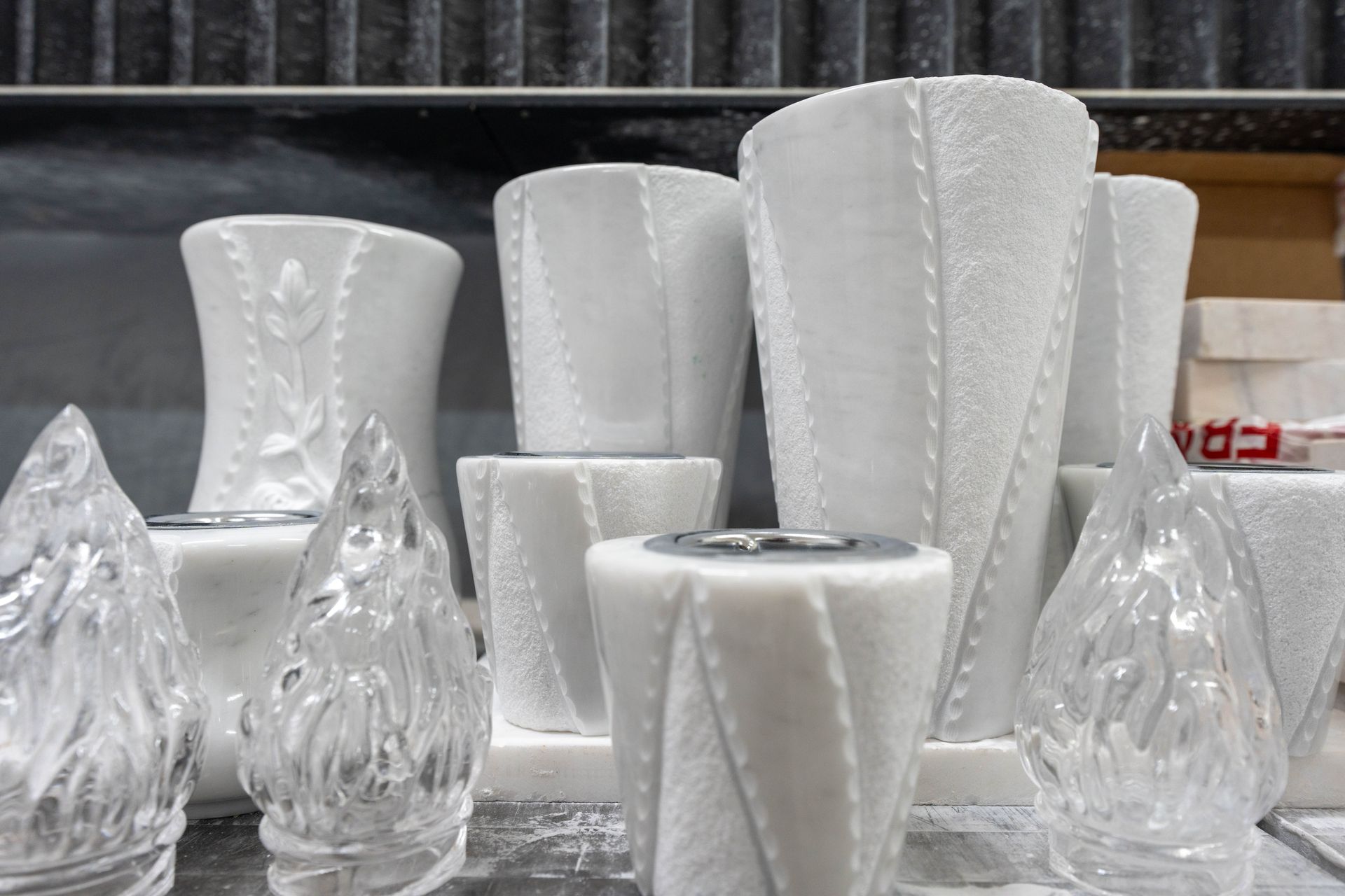 Un mazzo di vasi bianchi e candele sono appoggiati su un tavolo.