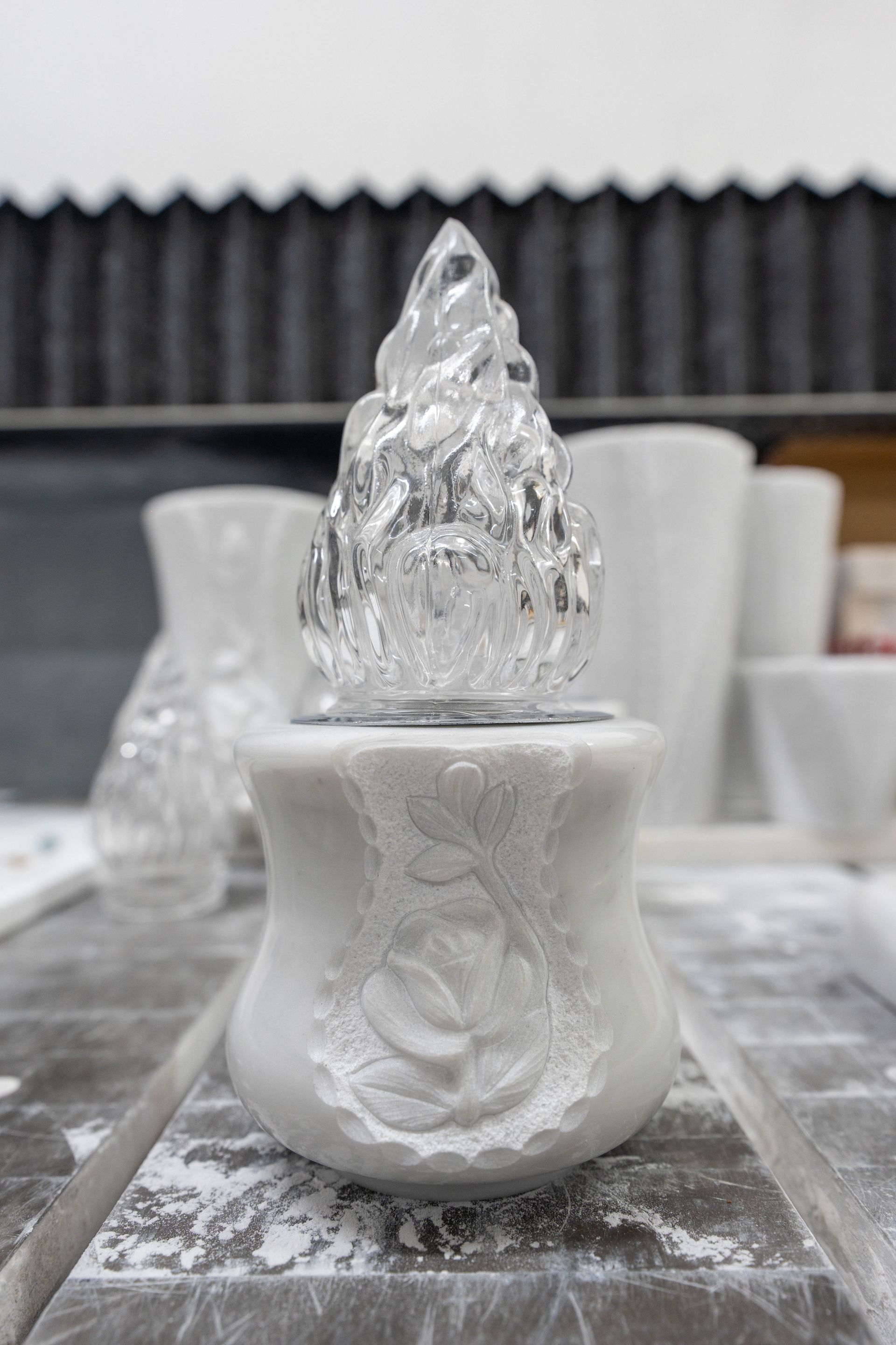 Un vaso bianco con una luce al suo interno è appoggiato su un tavolo.