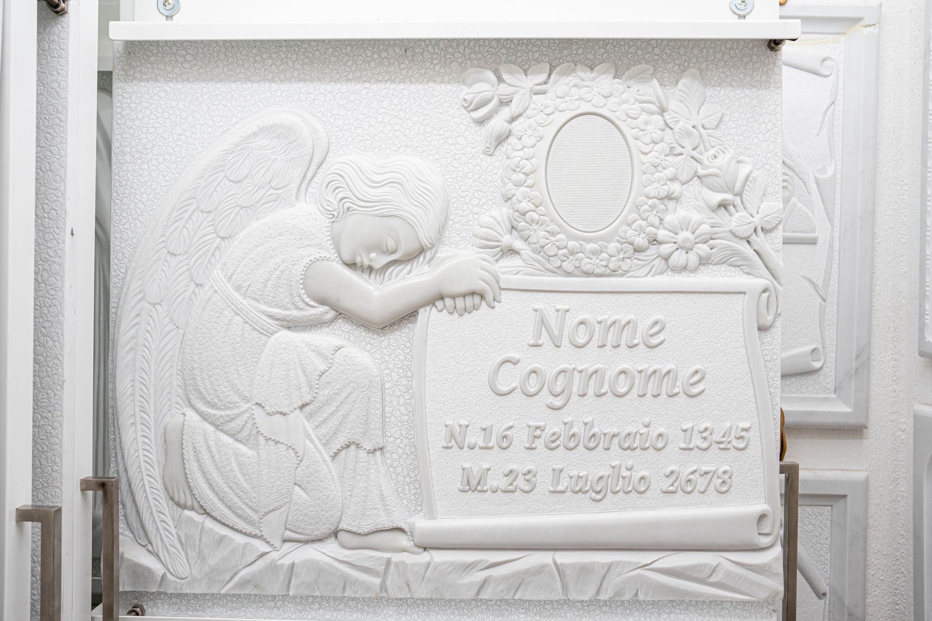 Una targa bianca con un angelo addormentato.