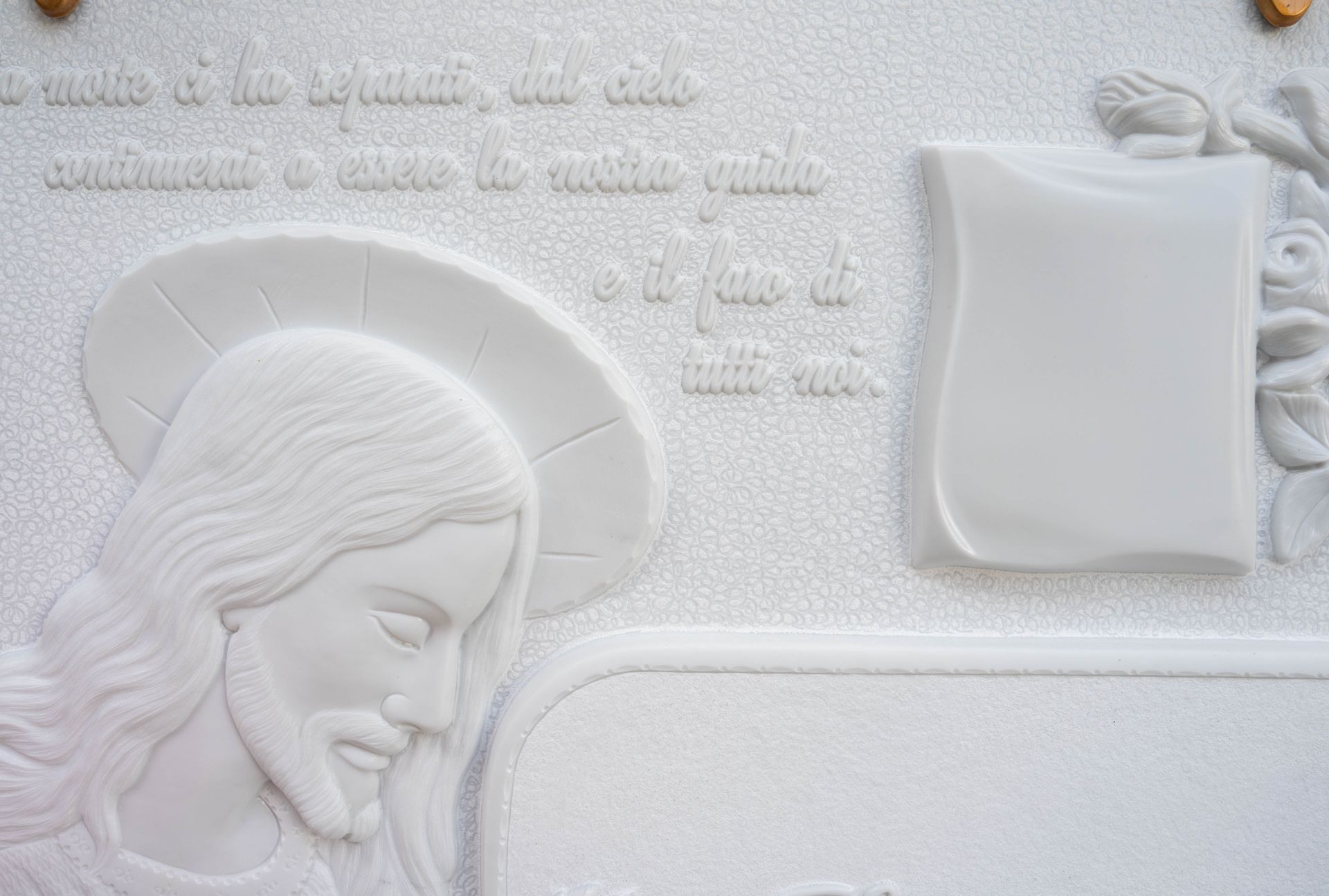 C'è una statua di Gesù su un muro bianco.