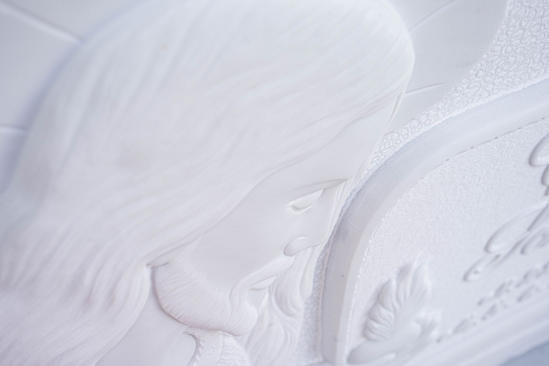 Un primo piano di una cassettiera bianca con sopra la statua di un angelo.