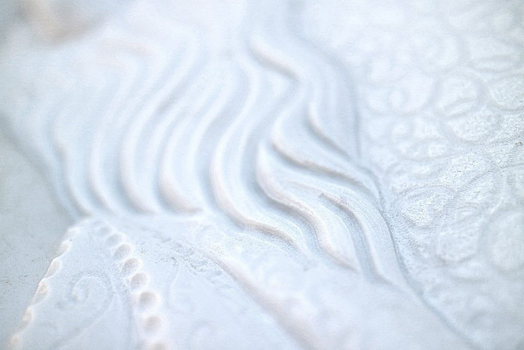Un primo piano di una superficie bianca con delle onde.