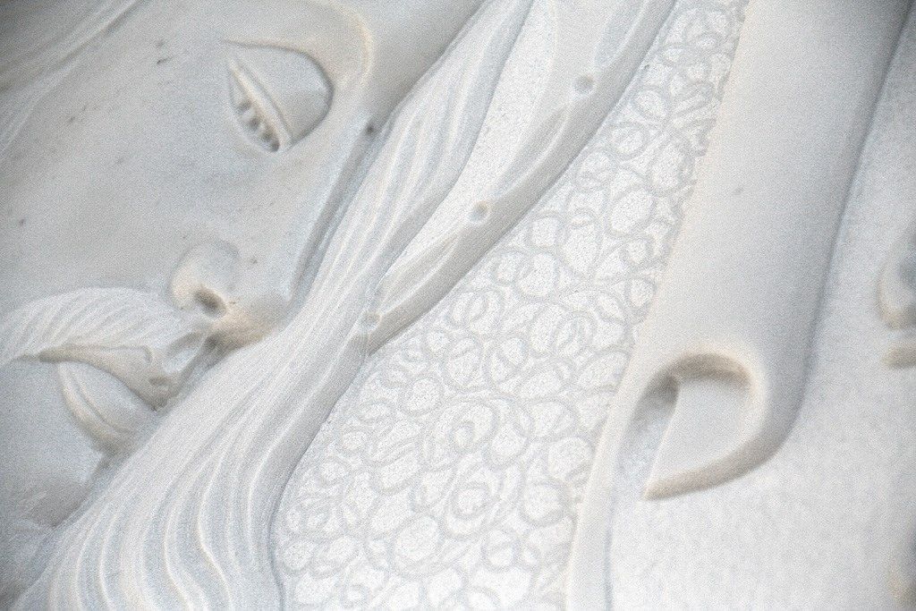 Un primo piano della statua di un uomo con la barba su un muro.