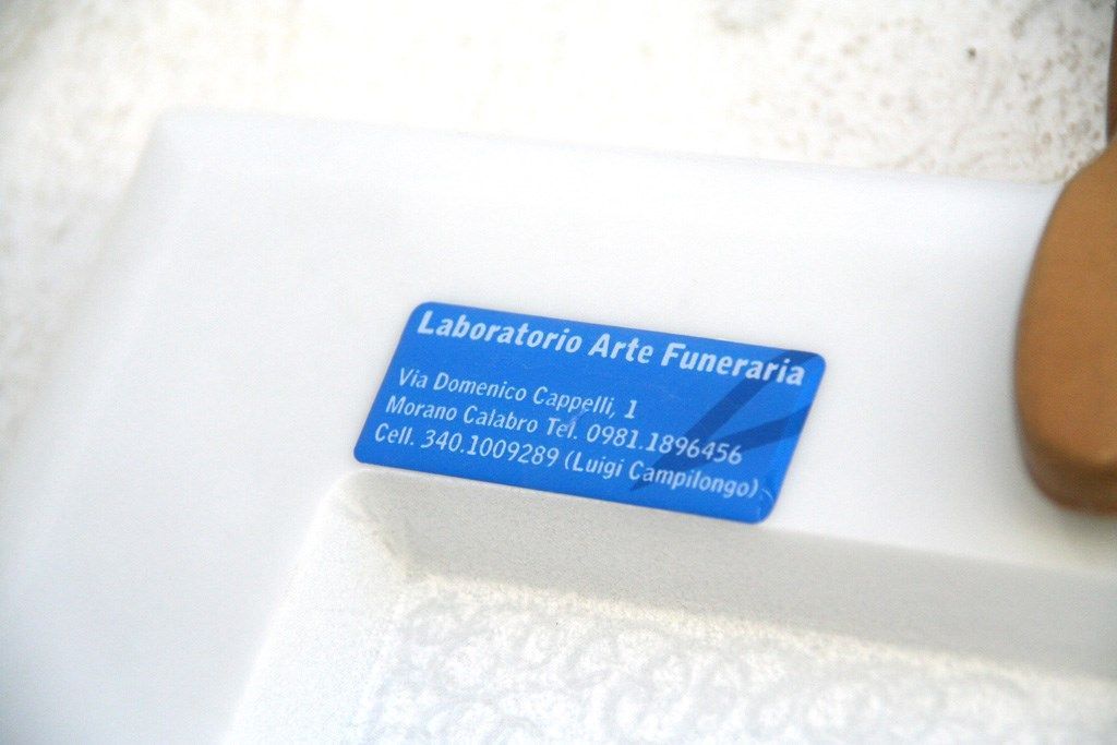 Un'etichetta blu con scritto laboratorio d'arte funeraria