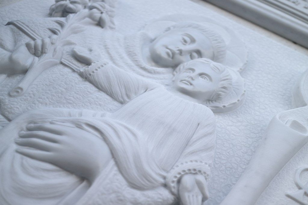 Un primo piano di una statua di una donna che tiene in braccio un bambino.