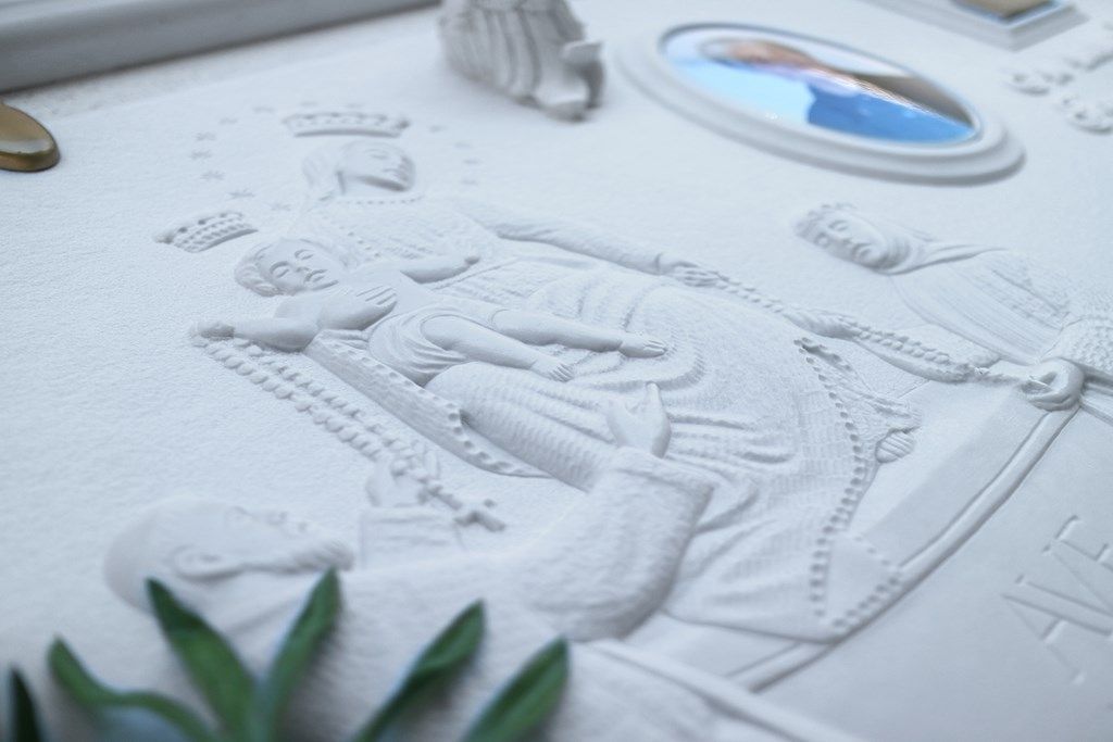 Una statua di una donna sdraiata su un letto con un'immagine sullo sfondo