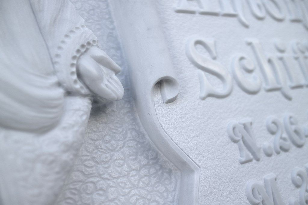 Un primo piano di una statua di Gesù su una tomba.