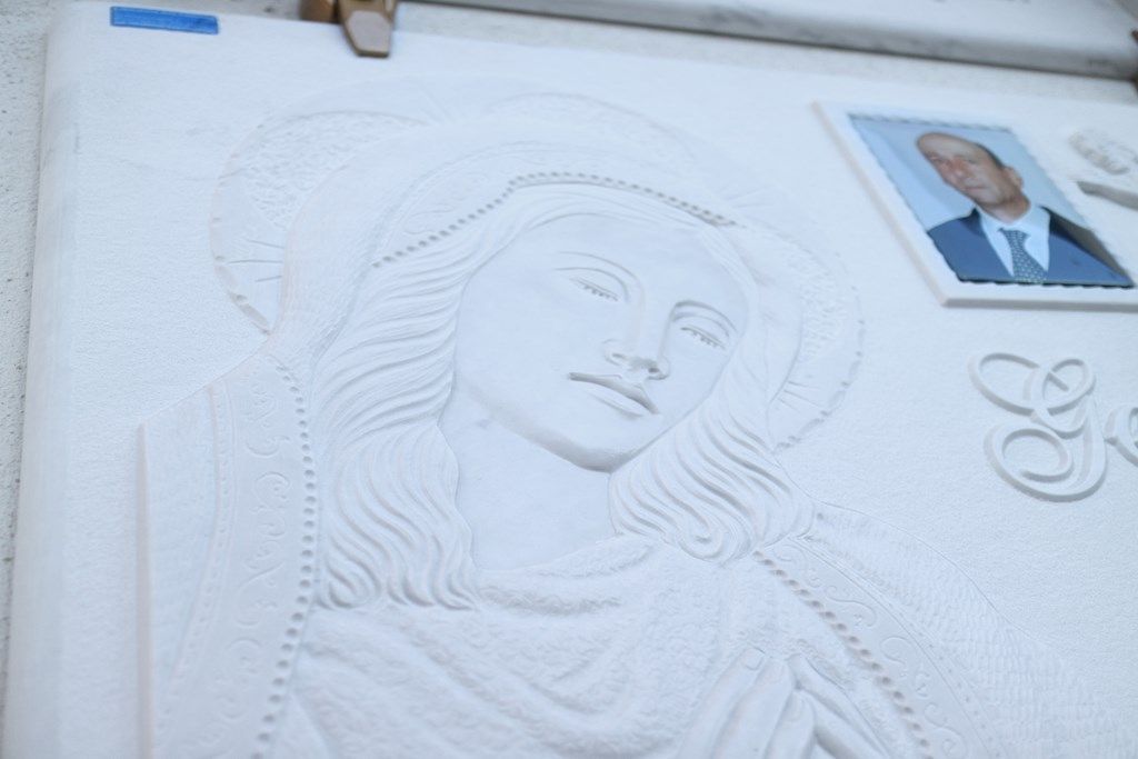 Una statua di una donna con un uomo in giacca e cravatta dietro di lei