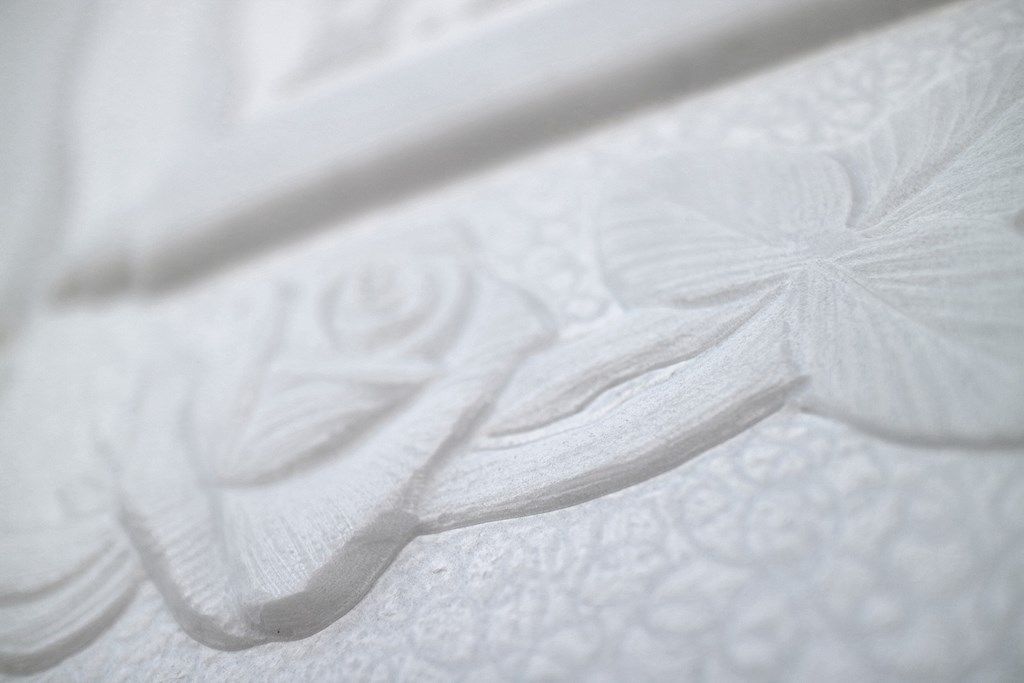 Primo piano di una piastrella bianca con un motivo floreale.