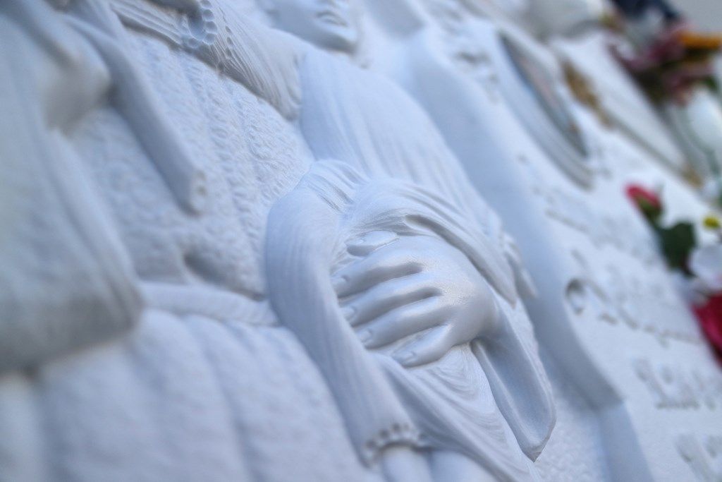 Una statua di una donna con le mani sul viso