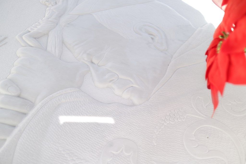 Un primo piano di un asciugamano bianco con un fiore rosso sullo sfondo.