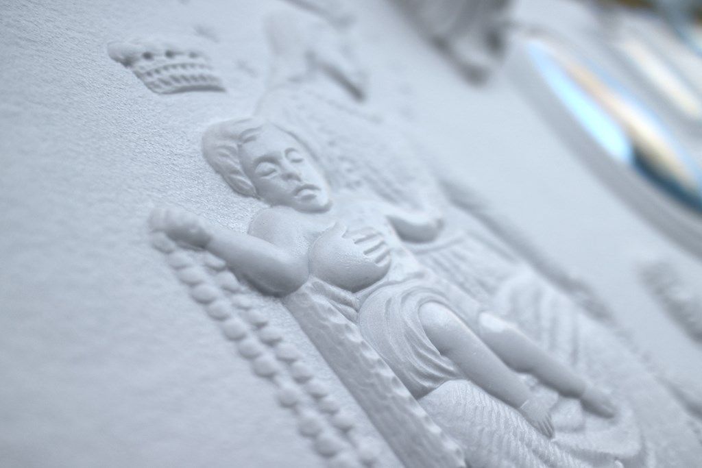 Un primo piano di una statua di Gesù su una superficie bianca.