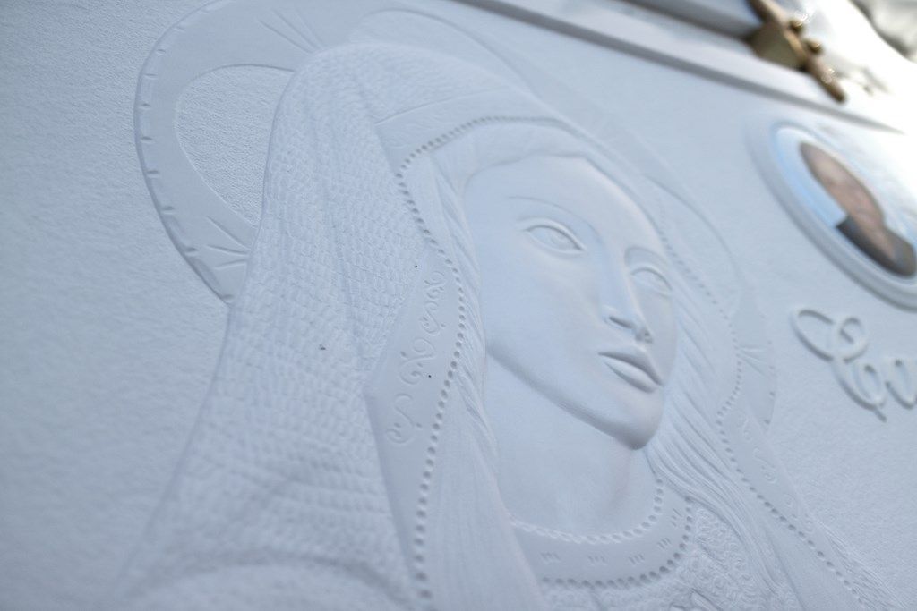 Un primo piano di una statua di una donna su un muro.